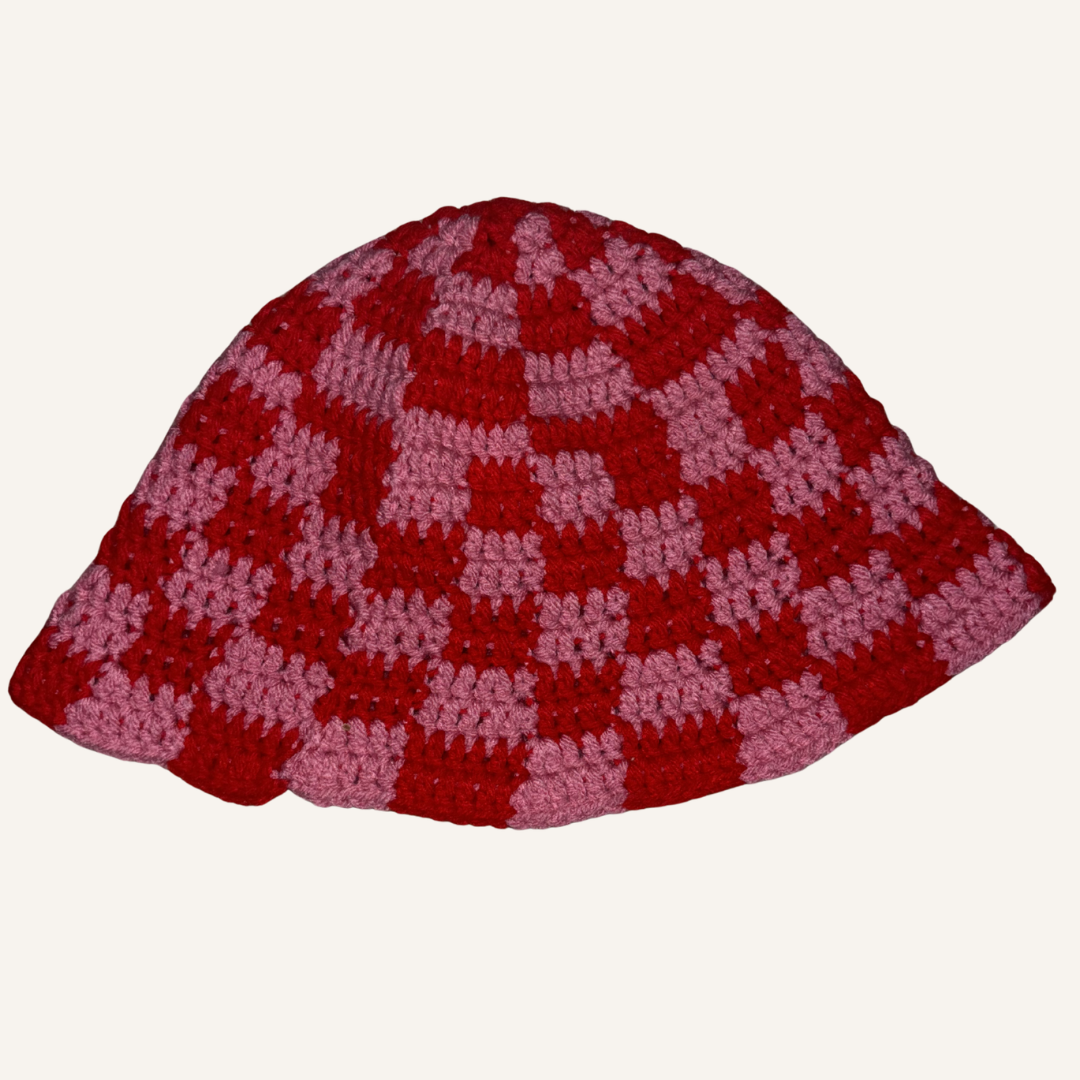 Red and pink checkered crocheted hat on a white background