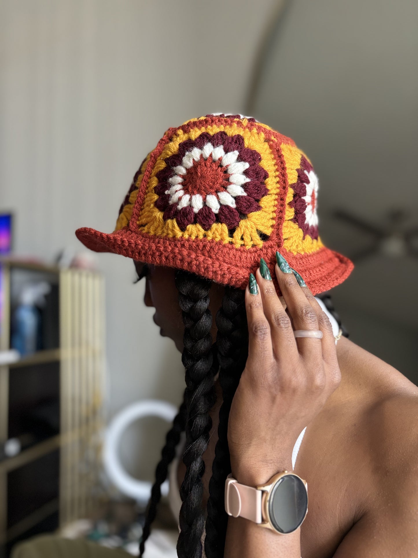 Person wearing a colorful crochet hat with a blurred indoor background