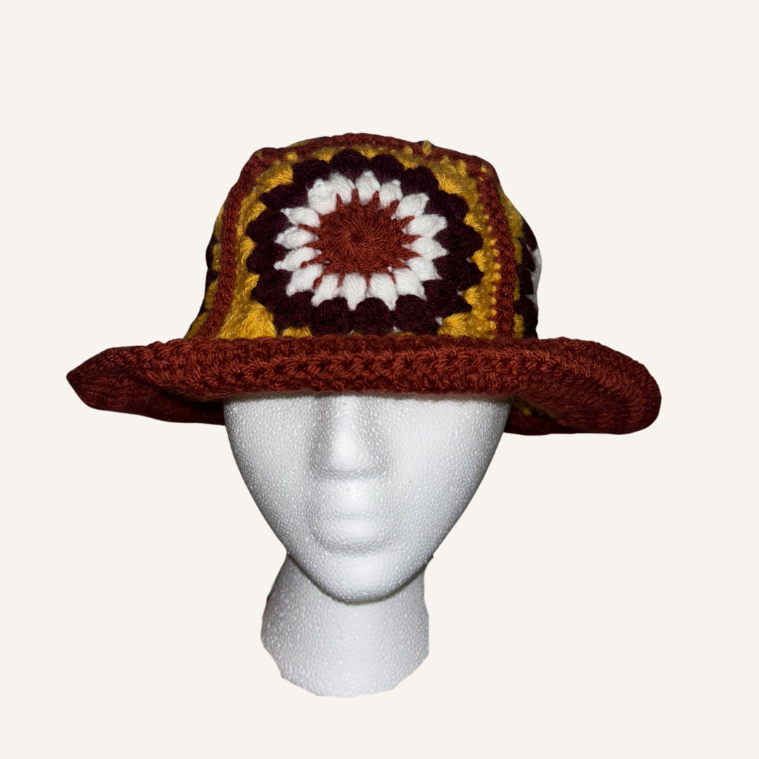Crocheted hat with a colorful pattern on a mannequin head against a white background