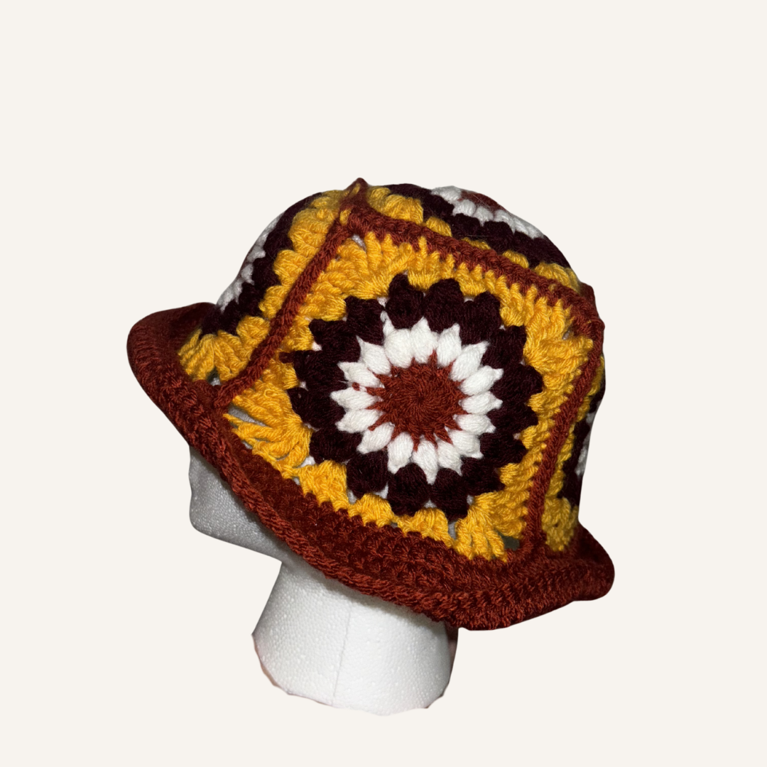 Colorful crocheted hat on a mannequin head against a white background