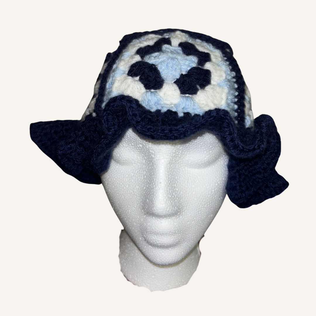 Crochet hat with granny square pattern on a mannequin head against a white background