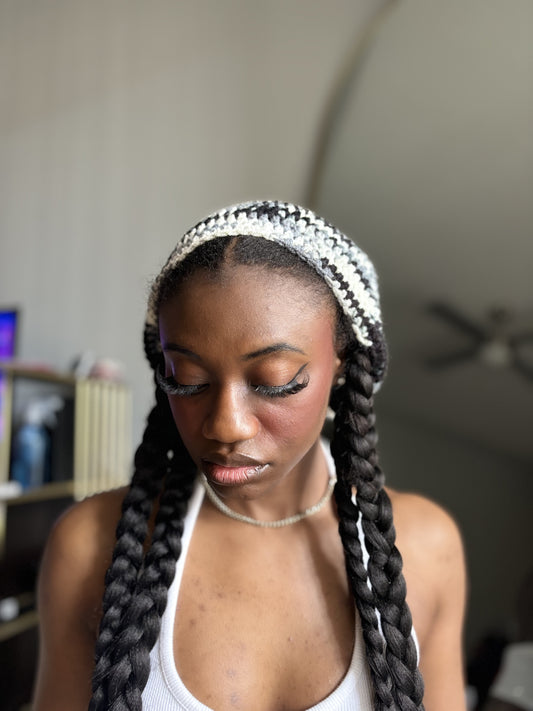 Woman with braided hair wearing a crochet beret indoors