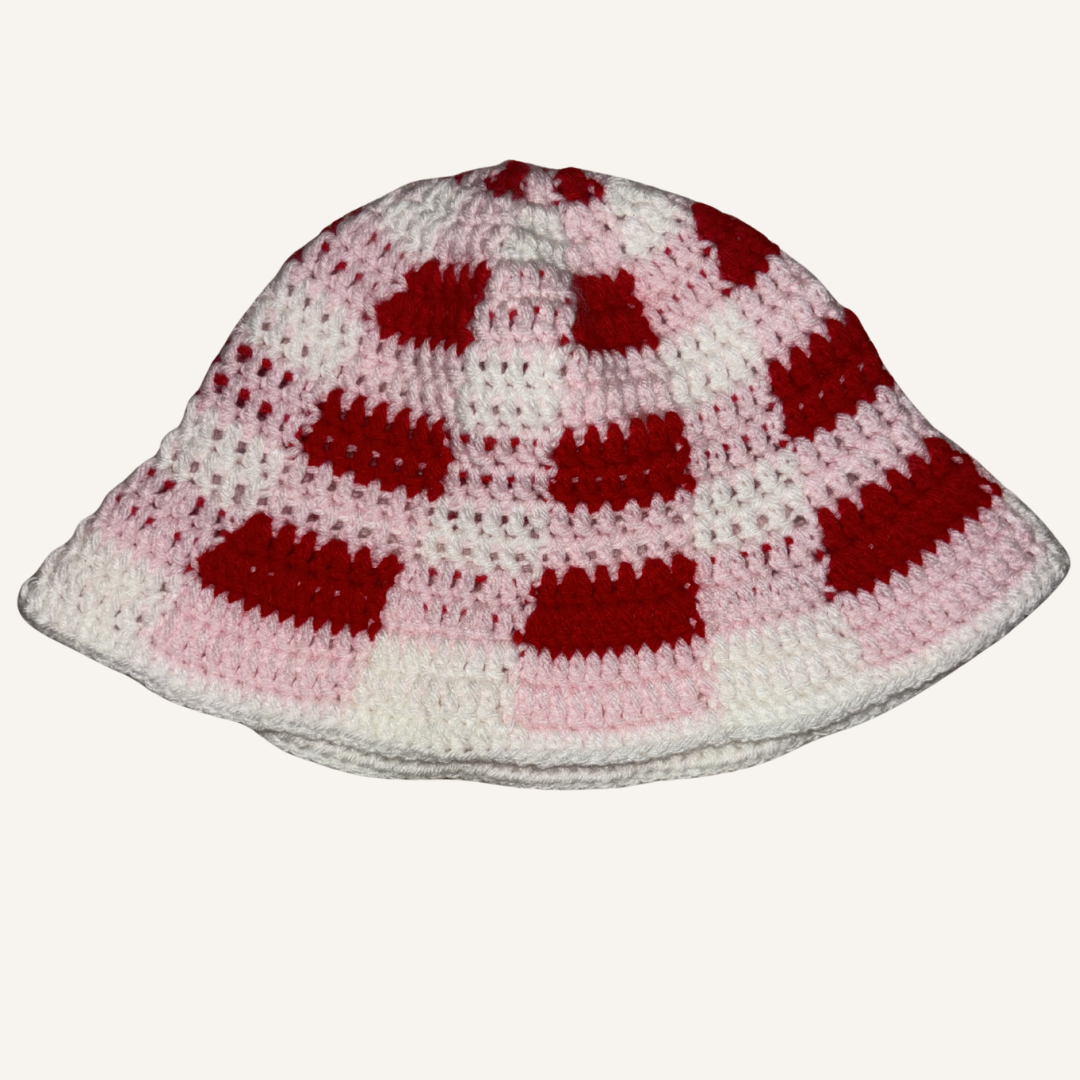 Hand-crocheted white, pink and red plaid hat on a white background
